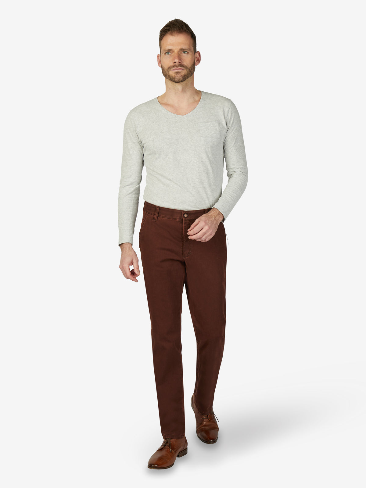 Mann trägt eine ziegelrote GARVEY 7218 Flat Front-Hose aus Baumwolle mit High Stretch, elastischem Komfortbund, Hemdenstopper, normaler Leibhöhe und schmaler Fußweite, ideal für Herbst/Winter.