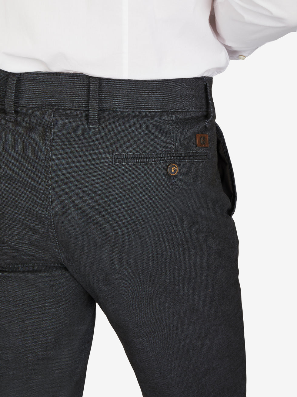 Nahaufnahme einer schwarzen Flat Front-Hose von GARVEY in Größe DE Kurz, hergestellt von Club of Comfort. Die Hose hat einen elastischen Komfortbund, eine schmale Fußweite und eine dezente kleine Logostickerei. Das Material ist Baumwoll-Struktur-Mischgewebe mit Woll-Optik, meliert in marine blau. Perfekt für Herbst/Winter, mit Stretch und OEKO-TEX Standard 100.