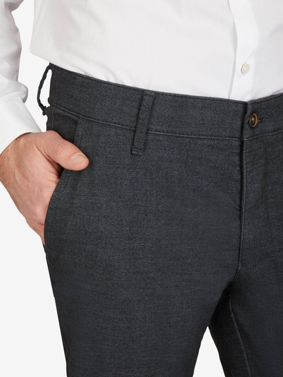 Nahaufnahme einer schwarzen Flat Front-Hose von Club of Comfort, mit elastischem Komfortbund und Hemdstopper, aus Baumwoll-Struktur-Mischgewebe mit Woll-Optik, normaler Leibhöhe, schmaler Beinverlauf, perfekt für Herbst/Winter, mit sichtbarem Gürtel und Knopf.