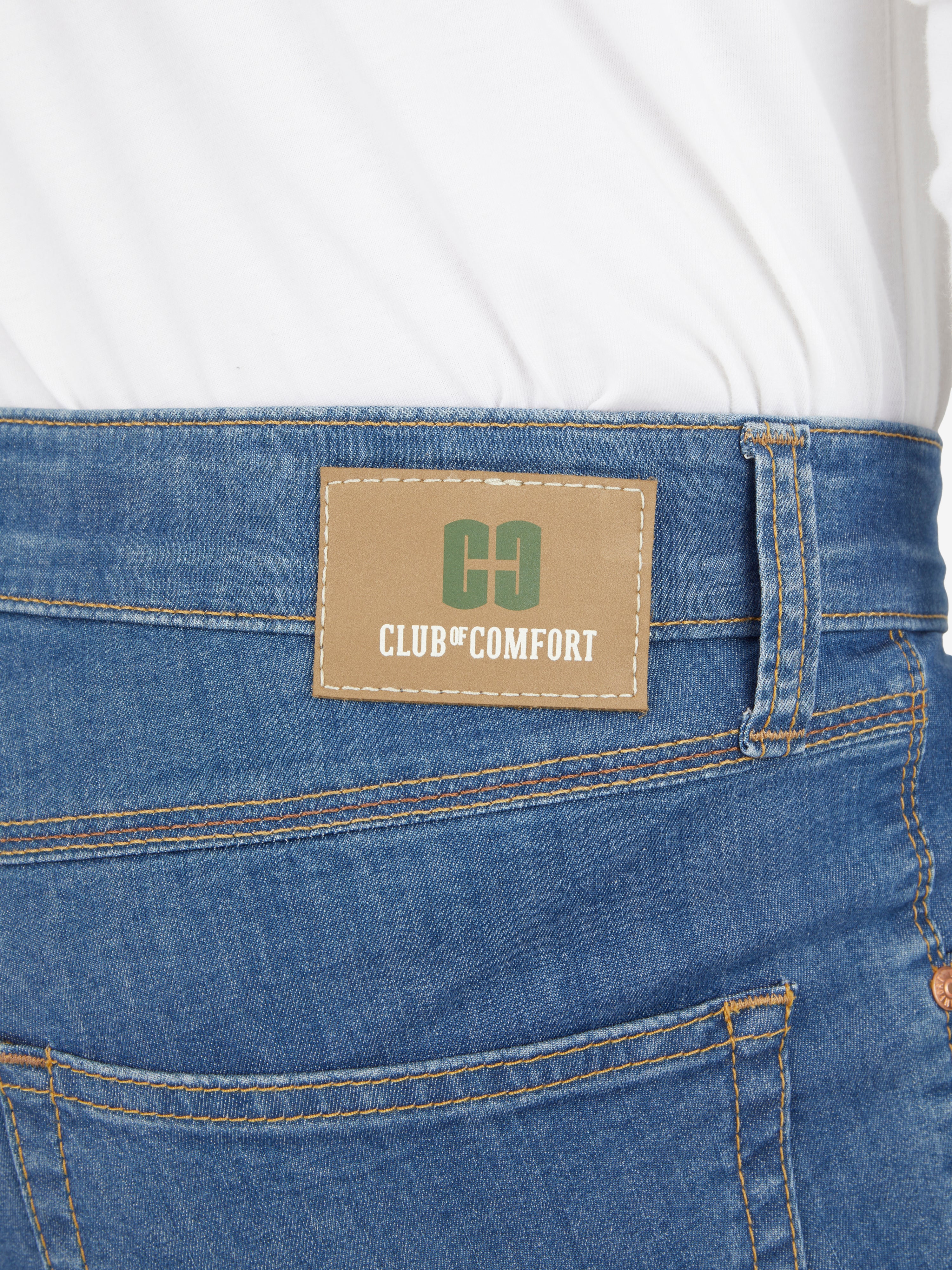 Nahaufnahme der blauen 5-Pocket-Jeans von Club of Comfort mit elastischem Doppelstoffbund, Mobile Pocket in der rechten Vordertasche, Münztasche mit Kontrast-Patch, hergestellt aus hoch elastischem Super High Stretch-Denim, mit Label auf der Hüfte.