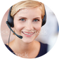 Nahaufnahme einer jungen Frau mit blonden Haaren, die freundlich lächelt und einen schwarzen Headset mit Mikrofon trägt, während sie sich offensichtlich in einem Kundenservice- oder Support-Umfeld befindet.