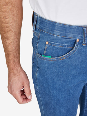 Nahaufnahme einer Person, die eine blaue Bermuda-Shorts aus elastischem Super High Stretch-Denim mit Komfortbund und Hemdenstopper trägt. Die Shorts haben klassische 5-Pocket-Form, sichtbare Nähte, Gürtelösen und einen kleinen grünen Markenknopf. Das Produkt ist von Club of Comfort, Modell ESPANA 6516, geeignet für Frühling und Sommer, mit normaler Leibhöhe.