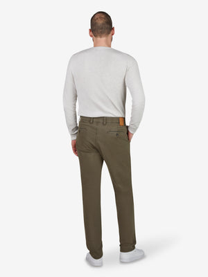 Ein Mann trägt eine grüne GARVEY 8070 Flat Front-Hose mit elastischem Komfortbund, Hemdstopper und Münztasche, gefertigt aus bi-elastischer Baumwoll-Qualität. Der Look ist bequem, sportlich und ideal für das Ganzjahres-Saison.