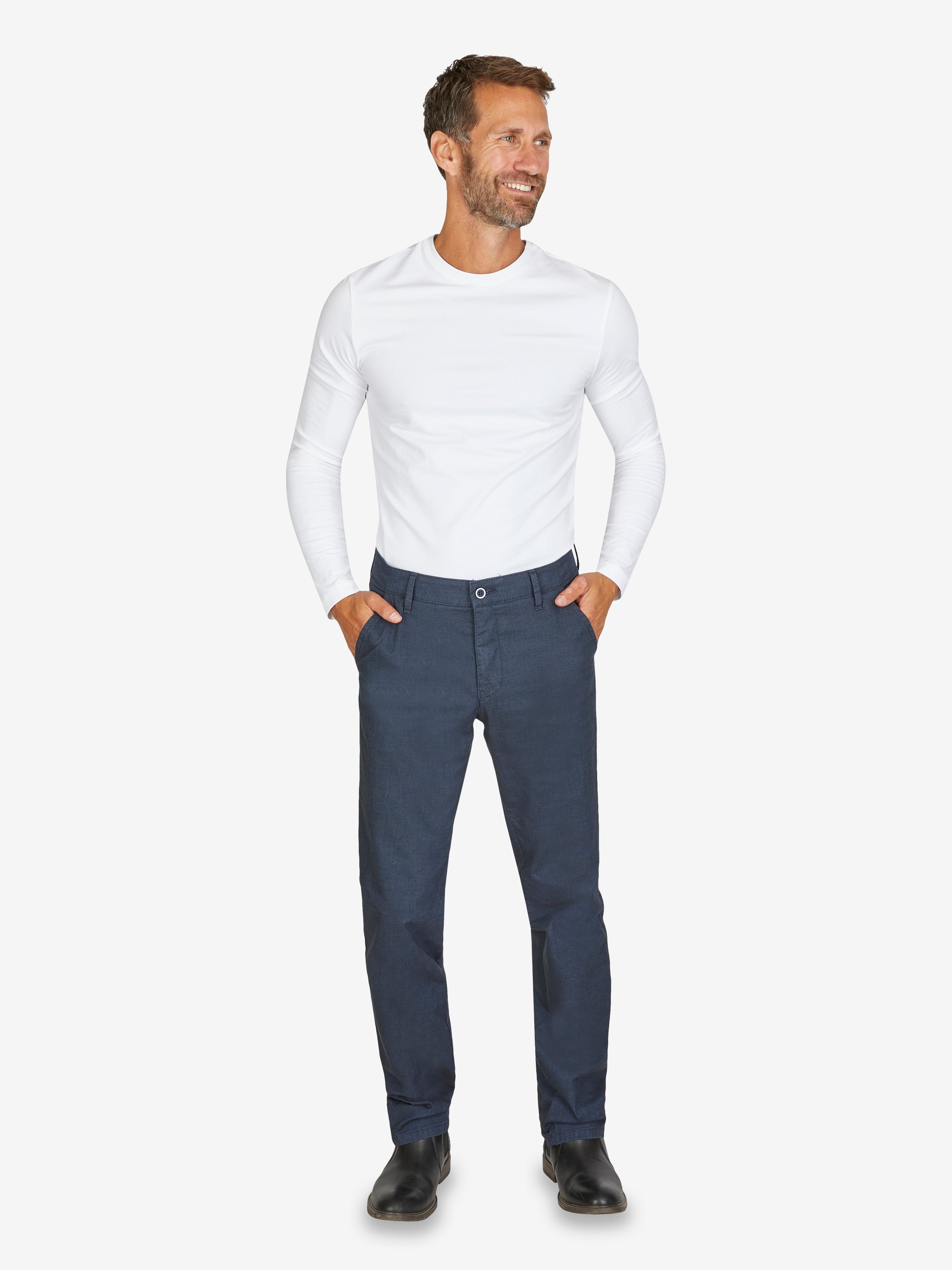 Mann trägt eine dunkelblaue GARVEY 6910 Flat Front-Hose mit elastischem Komfortbund, Hemdstopper und schmaler Fußweite, kombiniert mit weißem Langarmshirt. Die Hose ist aus Baumwoll-Mikrostruktur im Wool-Look, geeignet für Frühjahr/Sommer, mit Regular-Fit, Stretch und OEKO-TEX Standard 100.