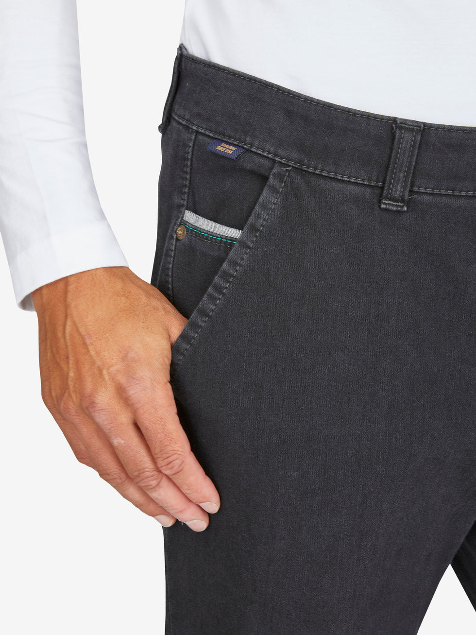 Nahaufnahme einer schwarzen Flat Front-Hose aus Bi-Stretch-Denim mit elastischem Komfortbund, Hemdstopper und Münztasche in der rechten Seitentasche. Das Modell zeigt eine schmale Passform, normale Leibhöhe und sportliche Details.