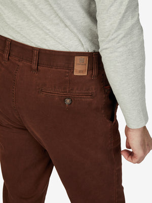 Nahaufnahme einer ziegelroten GARVEY 7218 Flat Front-Hose mit elastischem Komfortbund, Hemdenstopper und Münztasche. Die Hose besteht aus Pima-Baumwolle mit High Stretch, gefärbt mit Double Dye für einen winterlichen Look.