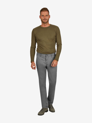 Mann trägt eine graue GARVEY 7708 Flat Front-Hose aus Baumwoll-High Stretch mit elastischem Komfortbund, Hemdenstopper und normaler Leibhöhe, kombiniert mit einem grünen Langarmshirt.