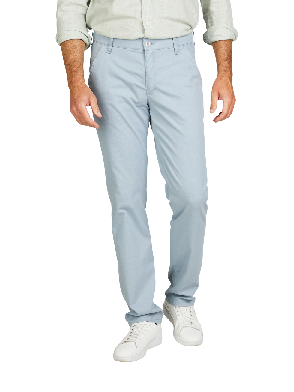 Mann trägt hellblaue Hosen, weißes Hemd mit hochgekrempelten Ärmeln und weiße Sneakers.