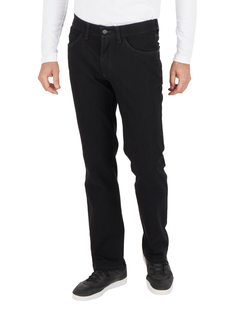 Bauchbedeckter Mann trägt schwarze Jeans, eine weiße lange Ärmel-T-SHirt, schwarze Schuhe mit weißen Sohlen, steht aufrecht, Hände locker an den Seiten.