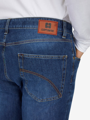 Nahaufnahme einer blauen, gewaschenen 6-Pocket-Hose von Club of Comfort mit elastischem Doppelstoffbund, Hemdstopper, separater "Mobile Pocket" für Smartphone, made aus superelastischem Bi-Stretch-Denim, reguläre Leibhöhe, schlankes Bein, sichtbar am Rücken mit Markenlabel "CLUB COMFORT".