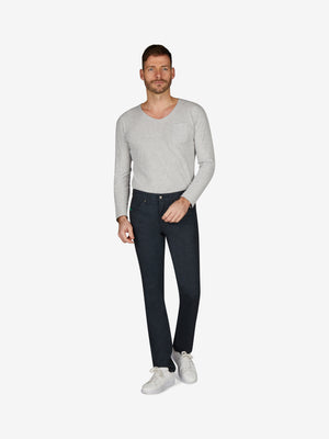 Mann trägt eine hellgraue Langarmbluse und dunkle Blau HENRY 7631 - marine melange 5-Pocket Jeans mit elastischem Komfortbund, Mobile Pocket in der rechten Vordertasche, Münztasche mit Kontrast-Patch, hergestellt aus Baumwoll-Wolloptik-Gemisch, für Herbst/Winter, regular Fit, schlankes Bein, auf weißem Hintergrund.