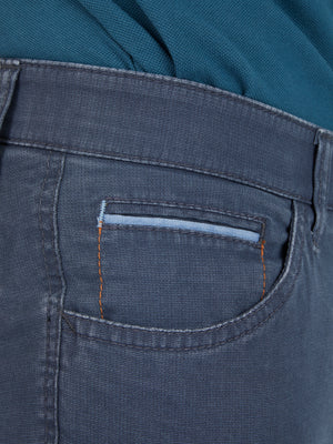 Nahaufnahme einer mittelblauen Hose "MARVIN 7506" von Club of Comfort mit elastischem Comfortbund, Hemdenstopper, doppelt paspelierter Münztasche mit Kontrast-Patch, aus High Stretch-Baumwolle in Mikrostruktur, mit schlanker Leibhöhe und schmalem Bein.