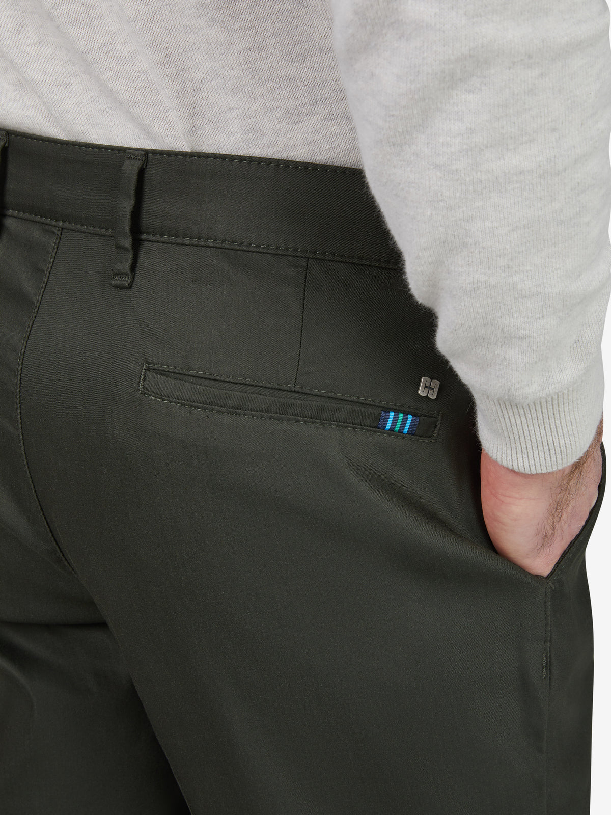 Dunkelgrüne Chino-Hose im Tapered Fit mit elastischem Comfortbund, Hemdenstopper und seitlicher Tasche mit grafischem Detail. Gefertigt aus High-Stretch-Techno-Cotton mit cleanem Look, normaler Leibhöhe, mehr Platz im Gesäß- und Oberschenkelbereich.