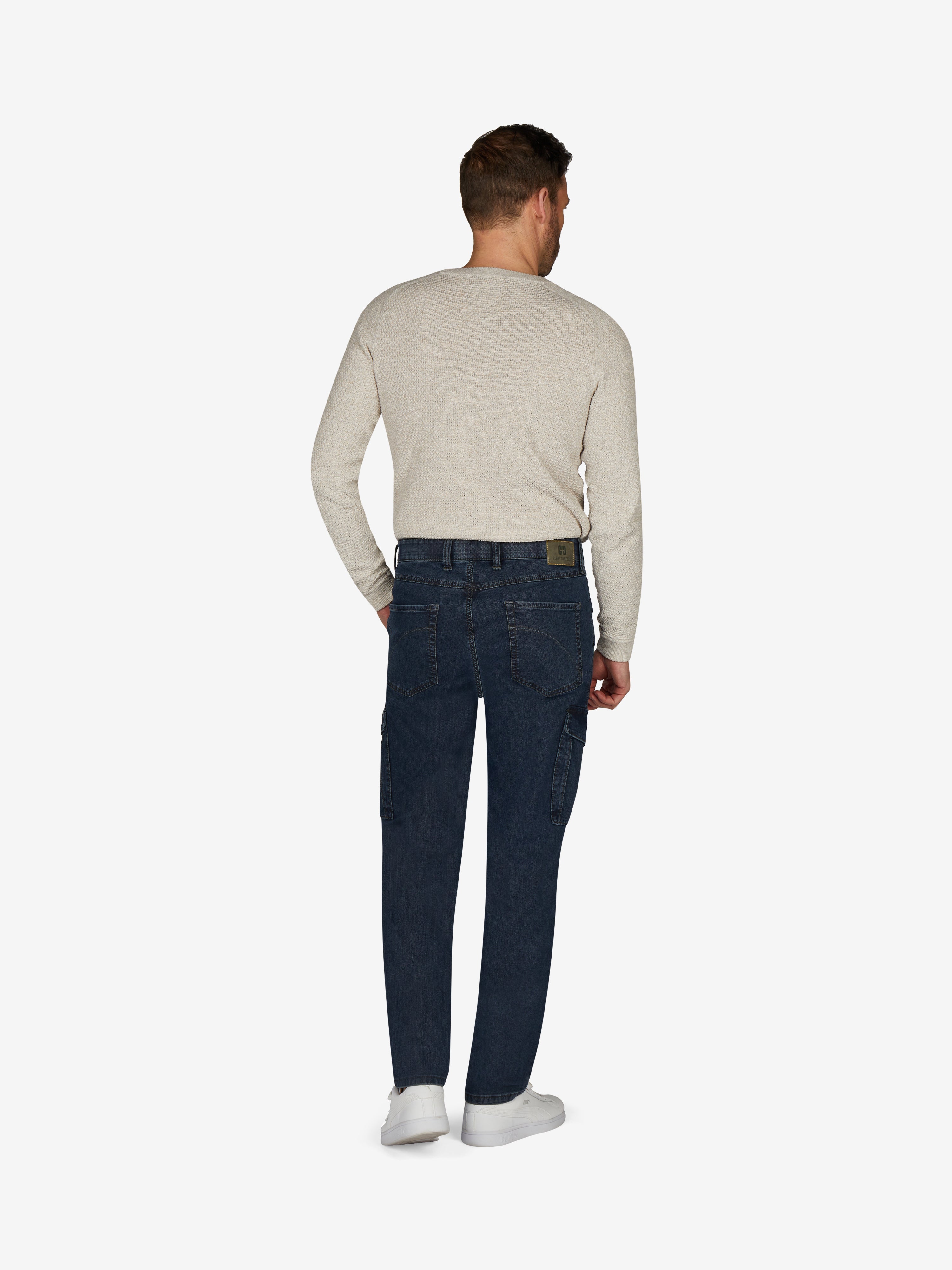 Rückansicht einer Person in einer blauen TANGO 8012 Cargohose im Tapered Fit mit elastischem Comfortbund, Hemdstopper, aufgesetzten Gesäßtaschen und Beintaschen mit Patte und Druckknopf, gefertigt aus High Stretch Denim mit filigranem Warenbild, hergestellt von Club of Comfort.